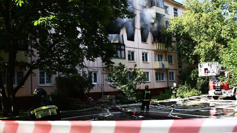 Сотрудники противопожарной службы у жилого дома на северо-востоке Москвы, где произошел хлопок газа