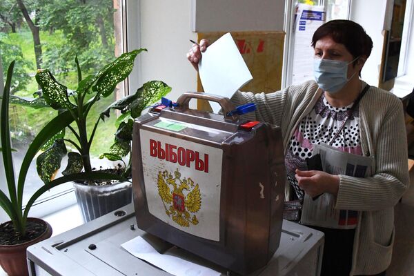 Женщина голосует по вопросу внесения поправок в Конституцию РФ на избирательном участке во Владивостоке