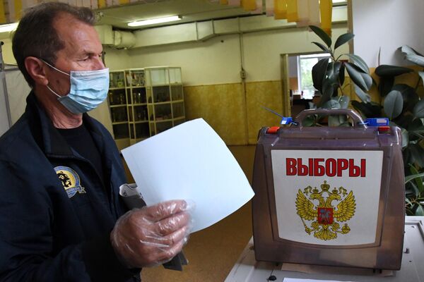 Мужчина голосует по вопросу внесения поправок в Конституцию РФ на избирательном участке во Владивостоке
