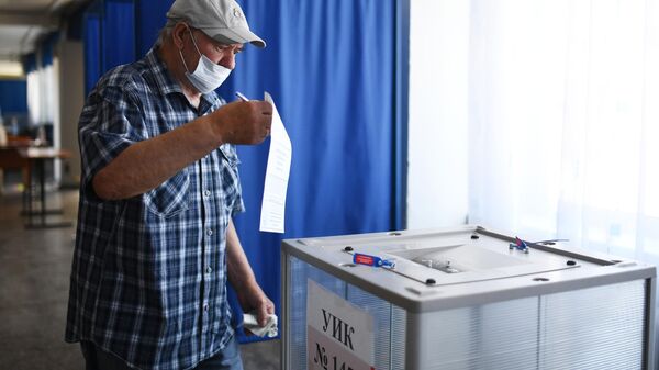 Мужчина голосует по вопросу внесения поправок в Конституцию РФ на избирательном участке в Новосибирске