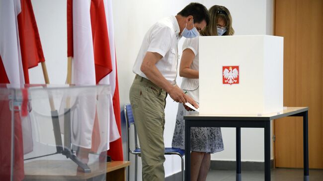 Избиратели во время голосования на выборах президента Польши на одном из избирательных участков в Варшаве