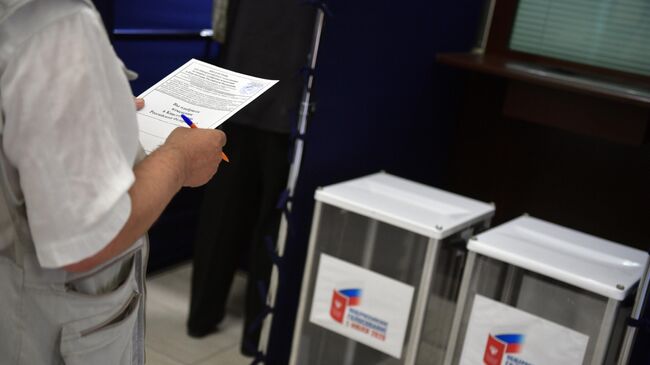Мужчина принимает участие в голосовании по вопросу одобрения изменений в Конституцию России