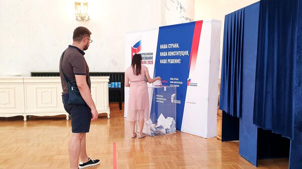 Девушка голосует по вопросу одобрения изменений в Конституцию России на избирательном участке в посольстве РФ в Пекине