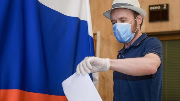 Мужчина голосует по вопросу изменений в Конституцию России на избирательном участке