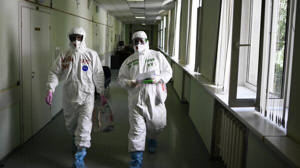 Члены избирательной комиссии в защитных костюмах в центральной клинической больнице РЖД-Медицина в Москве