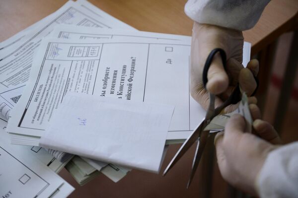 Член избирательной комиссии проводит процедуру гашения неиспользованных бюллетеней на избирательном участке №1331 в Екатеринбурге 