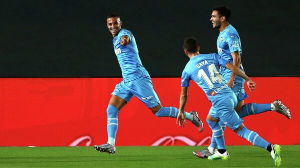 Нападающий Валенсии Родриго Морено празднует гол в ворота мадридского Реала с одноклубниками