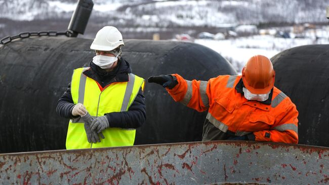 Моряки выгружают рыбу из транспортного судна (рефрижератора) Выборгский у причала Мурманского морского рыбного порта