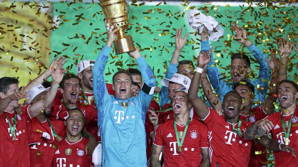 Bayern Munich's German goalkeeper Manuel Neuer raises the German Cup (DFB Pokal) trophy as he and his teammates celebrate winning the final football match Bayer 04 Leverkusen v FC Bayern Munich at the Olympic Stadium in Berlin on July 4, 2020. (Photo by Michael Sohn / POOL / AFP) / DFB REGULATIONS PROHIBIT ANY USE OF PHOTOGRAPHS AS IMAGE SEQUENCES AND QUASI-VIDEO.