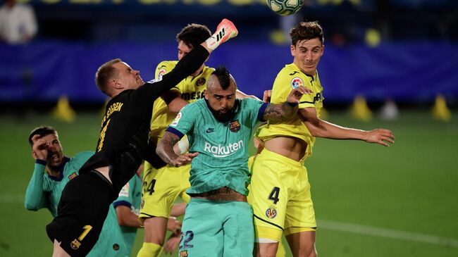 Barcelona's German goalkeeper Marc-Andre Ter Stegen (L) punches the ball away during the Spanish League football match between Villarreal and Barcelona at the Madrigal stadium in Villarreal on July 5, 2020. (Photo by JOSE JORDAN / AFP)