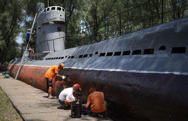 Местные жители красят корпус малой многоцелевой дизельной подводной лодки М-261, установленной в парке 30-летия Победы в Краснодаре