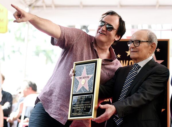 Итальянский композитор Эннио Морриконе с режиссером Квентином Тарантино во время церемонии вручения Морриконе звезды на Голливудской Аллее Славы в Лос-Анджелесе. 2016 год