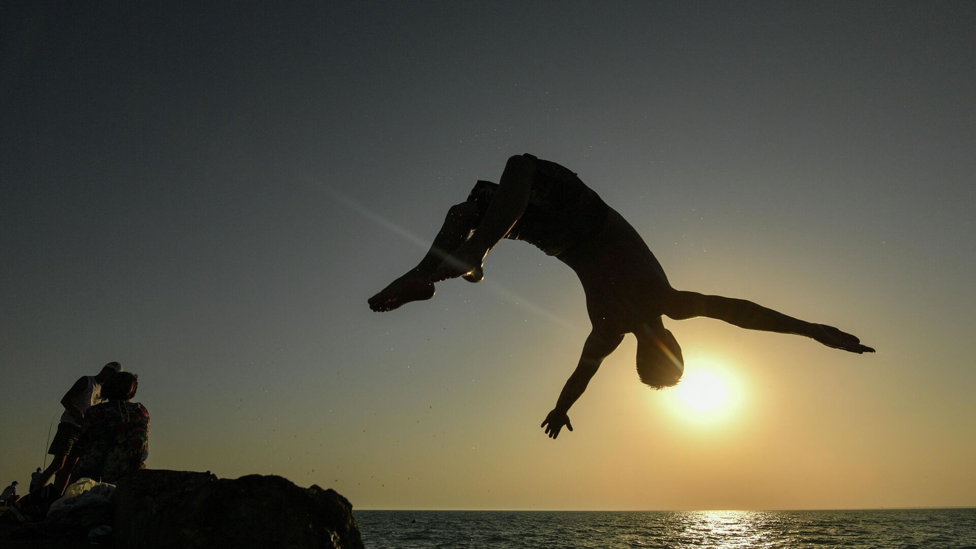 Мужчина прыгает с пирса на пляже в посёлке городского типа Новофёдоровка Сакского района - РИА Новости, 1920, 07.12.2020