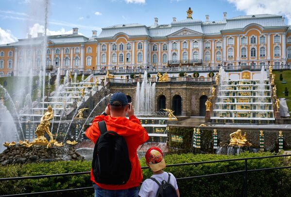 Посетители фотографируют фонтаны Большого каскада в Нижнем парке Государственного музея-заповедника Петергоф