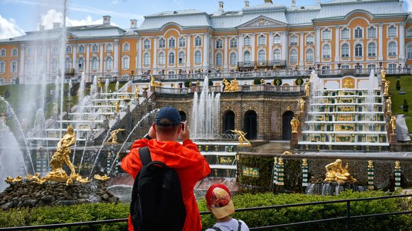 Посетители фотографируют фонтаны Большого каскада в Нижнем парке Государственного музея-заповедника Петергоф