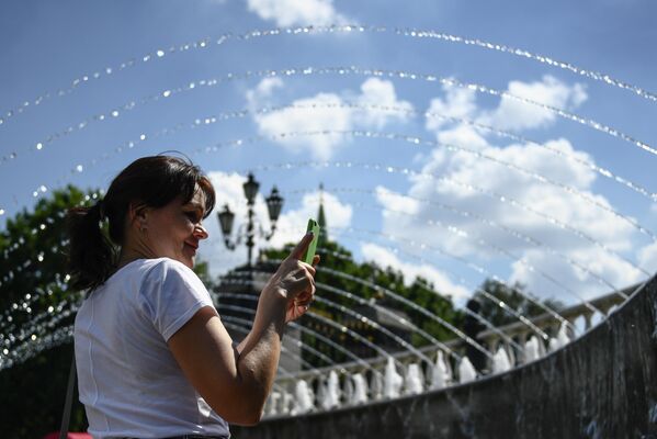 Женщина возле фонтана на Манежной площади в Москве