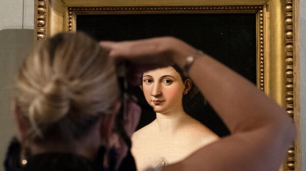 Женщина фотографирует картину Рафаэля Санти Форнарина в галерее Боргезе в Риме 