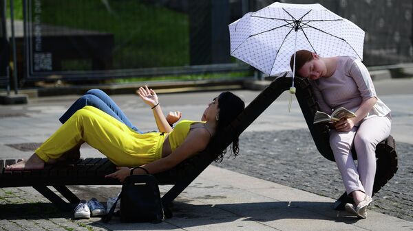 Девушки отдыхают у фонтана в жаркий день в парке искусств Музеон
