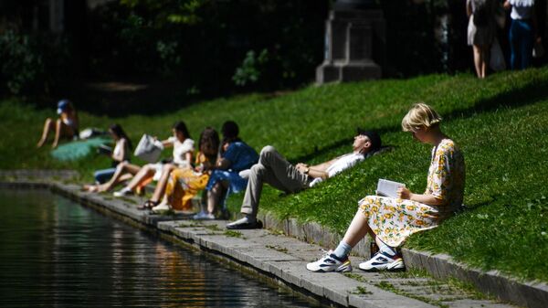 Люди в жаркий день отдыхают на Патриарших прудах в Москве