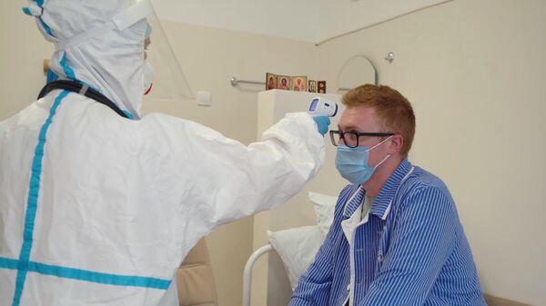 Врач проводит ежедневный обход-осмотр участника испытаний вакцины от коронавируса в Главном военном клиническом госпитале имени Н. Н. Бурденко