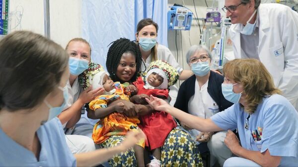Мама с разделенными сиамскими близнецами Эрвиной и Префиной в детской больнице Бамбино Джезу в Риме. Стоп-кадр видео