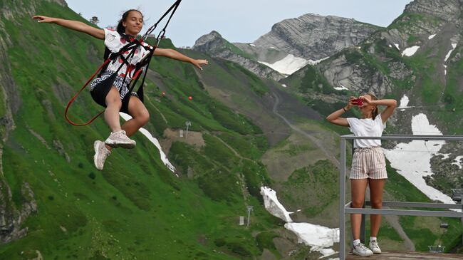 Отдыхающие на аттракционе высокогорные качели на горном курорте Красная Поляна