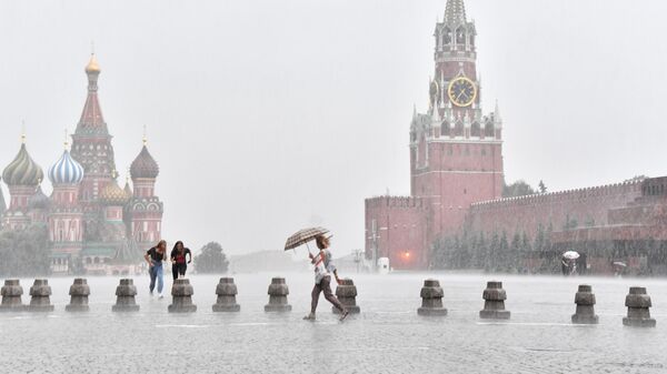 Люди под дождем на Красной площади в Москве