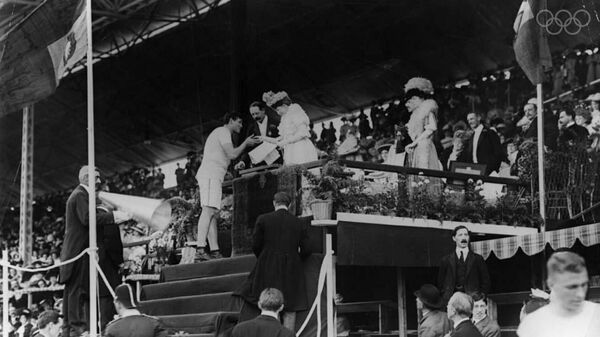 Королева Великобритании Александра вручает золотую медаль американскому легкоатлету Ральфу Роузу на Олимпийских играх 1908 года в Лондоне