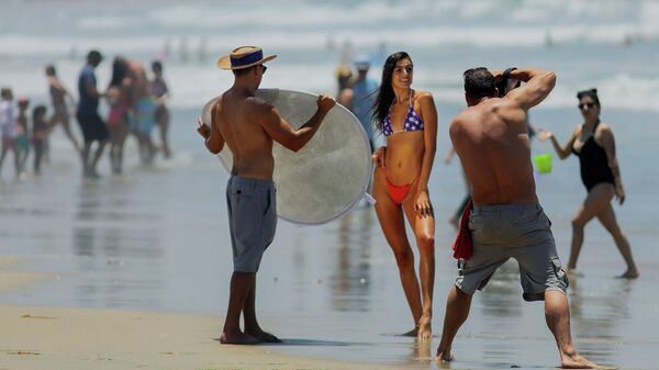 Девушка позирует фотографу на пляже в Сан-Диего, Калифорния