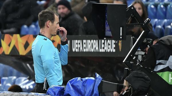 Арбитр обращается к системе VAR во время матча Лиги Европы УЕФА