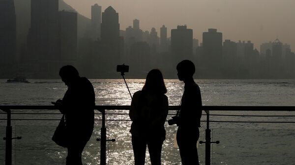 Пара делает селфи во время заката с видом на финансовый Центральный район Гонконга 