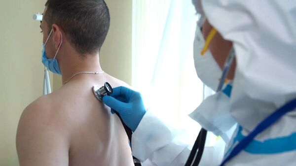 Врач проводит ежедневный обход-осмотр участника испытаний вакцины от коронавируса