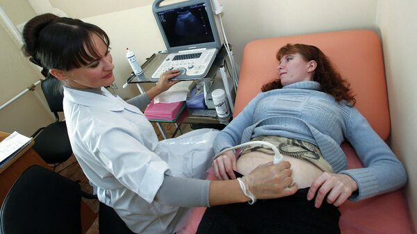 Женщина на приеме у врача в отделении экстракорпорального оплодотворения
