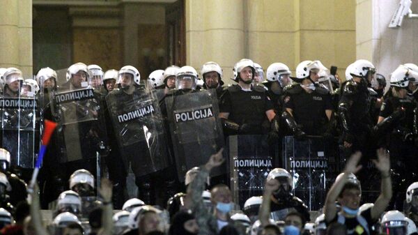 Участники акции протеста и сотрудники правоохранительных органов в центре Белграда