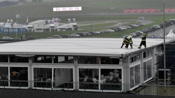 Firefighters remove water from the roof of the pit lane building during heavy rain during the third practice session for the Formula One Styrian Grand Prix on July 11, 2020 in Spielberg, Austria. (Photo by JOE KLAMAR / various sources / AFP)