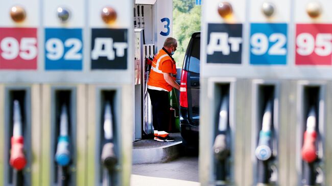 Сотрудник заправляет автомобиль на одной из автозаправочных станций Газпромнефть в Москве