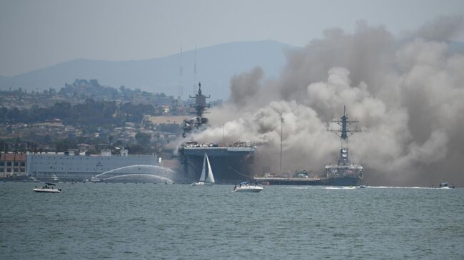 Smoke rises from the USS Bonhomme Richard at Naval Base San Diego Sunday, July 12, 2020, in San Diego after an explosion and fire Sunday on board the ship at Naval Base San Diego.