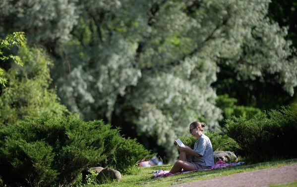 Девушка читает книгу в парке Дубки в Москве