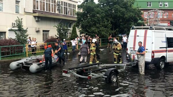 Сотрудники МЧС РФ на месте подтопления одной из улиц в центре Краснодара после мощного ливня