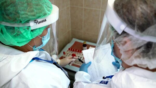 Врачи складывают пробирки с кровью для анализа перед выпиской добровольцев испытаний вакцины от коронавируса в Главном военном клиническом госпитале имени Н. Н. Бурденко