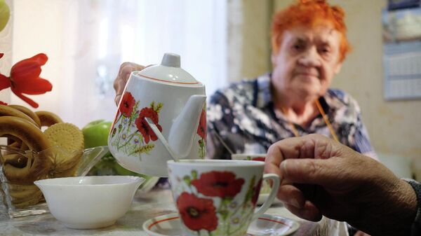 Пожилая семейная пара пьет чай у себя дома
