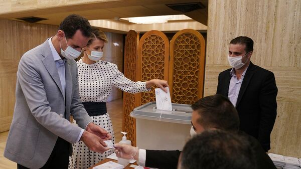 Президент Сирии Башар Асад и его супруга Асма во время голосования на парламентских выборах на избирательном участке в министерстве по делам президента в Дамаске