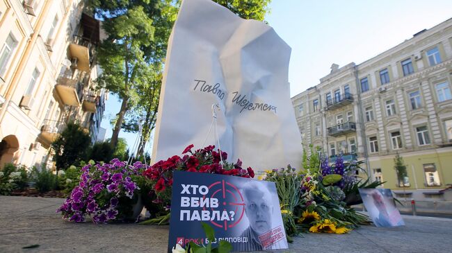 Цветы и фотографии у мемориала в честь журналиста Павла Шеремета в Киеве