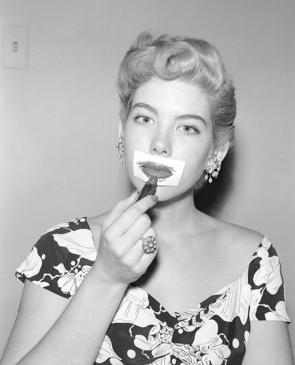 Миллисент Деминг наносит помаду с помощью трафарета для губ. 1953 год