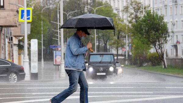 Мужчина с зонтом во время дождя