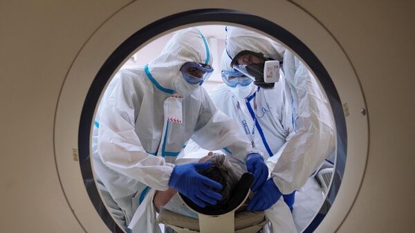 Медицинские работники готовят пациента к проведению компьютерной томографии