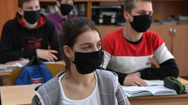 Ученики в защитных масках на уроке в общеобразовательной школе