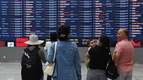 Пассажиры у электронного табло в терминале B аэропорта Шереметьево
