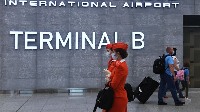 Пассажиры и стюардессы в терминале B аэропорта Шереметьево