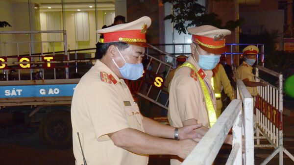 Полицейские в защитных масках перекрывают улицу в городе Дананг